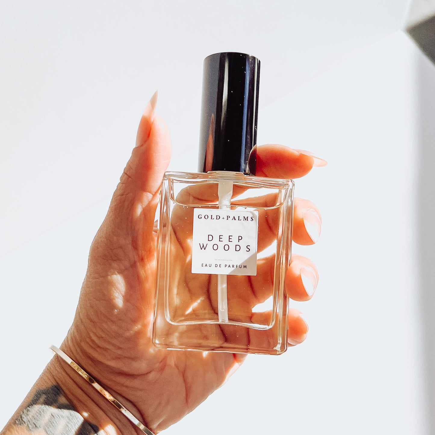 Deep woods perfume in hand white background