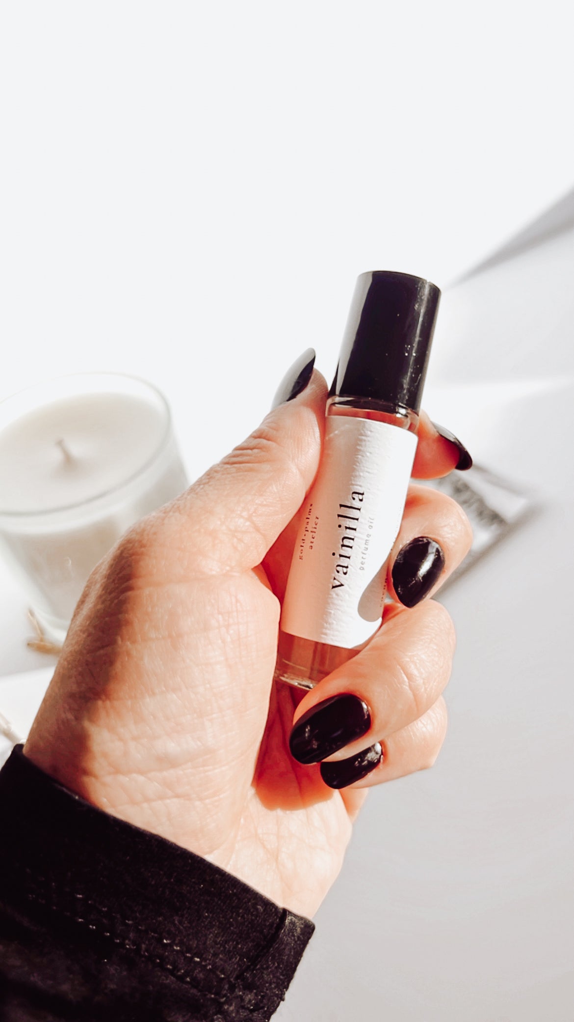 10 ml smokey vanilla oil rollerball perfume held against white background