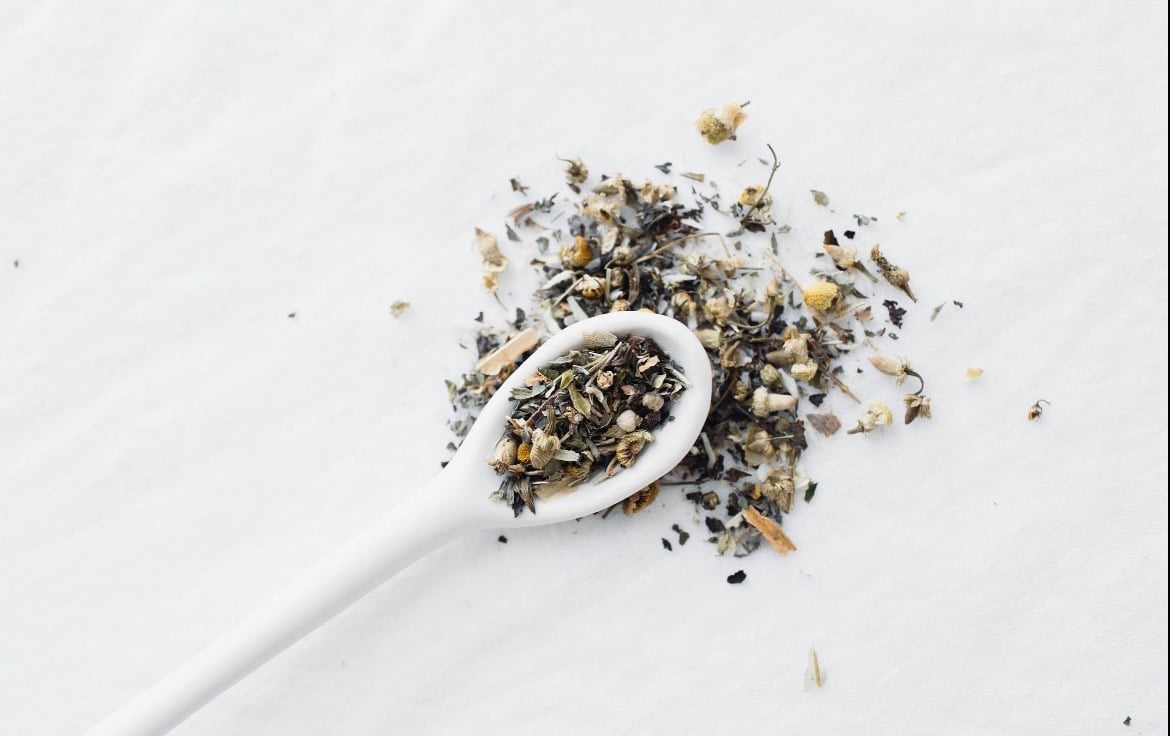 Aesthete tea with flowers on white spoon with white background
