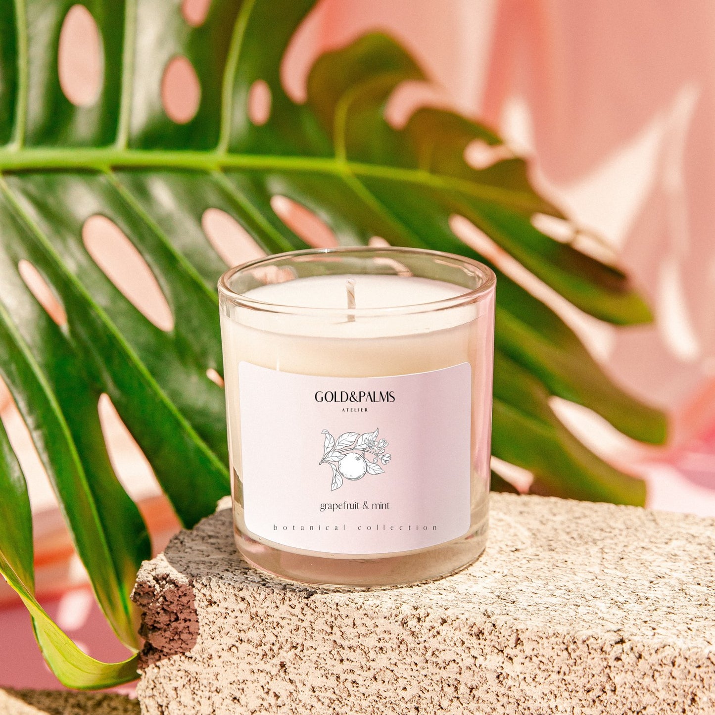Grapefruit and mint soy wax candle in clear 10 oz vessel with tropical background