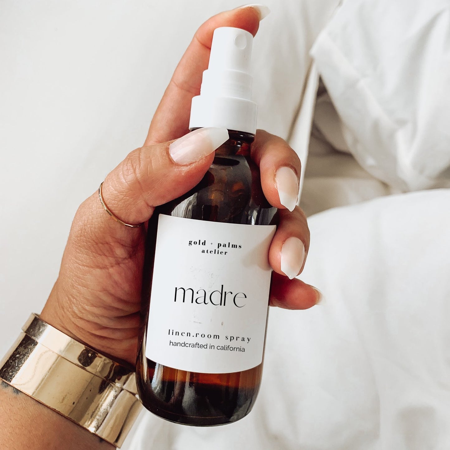 madre linen and room spray in amber glass bottle against white background