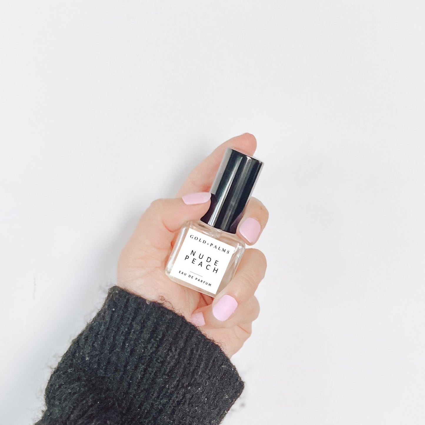 hand holding peach rum patchouli eau de parfum 15 ml