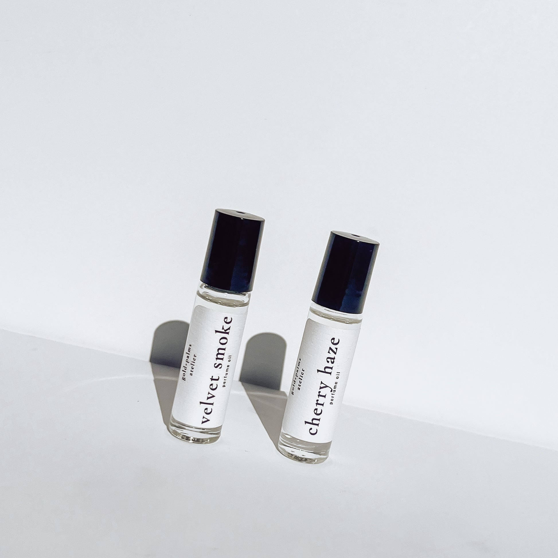 two 10 ml roller ball perfume oils with white background