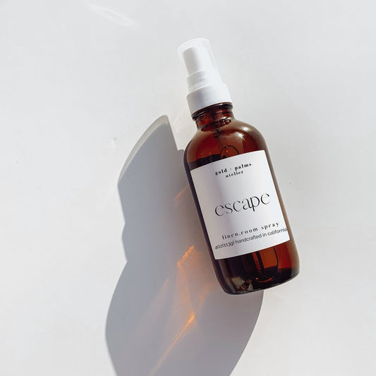 sea salt, orchid, tonka bean room spray in amber glass bottle against white background