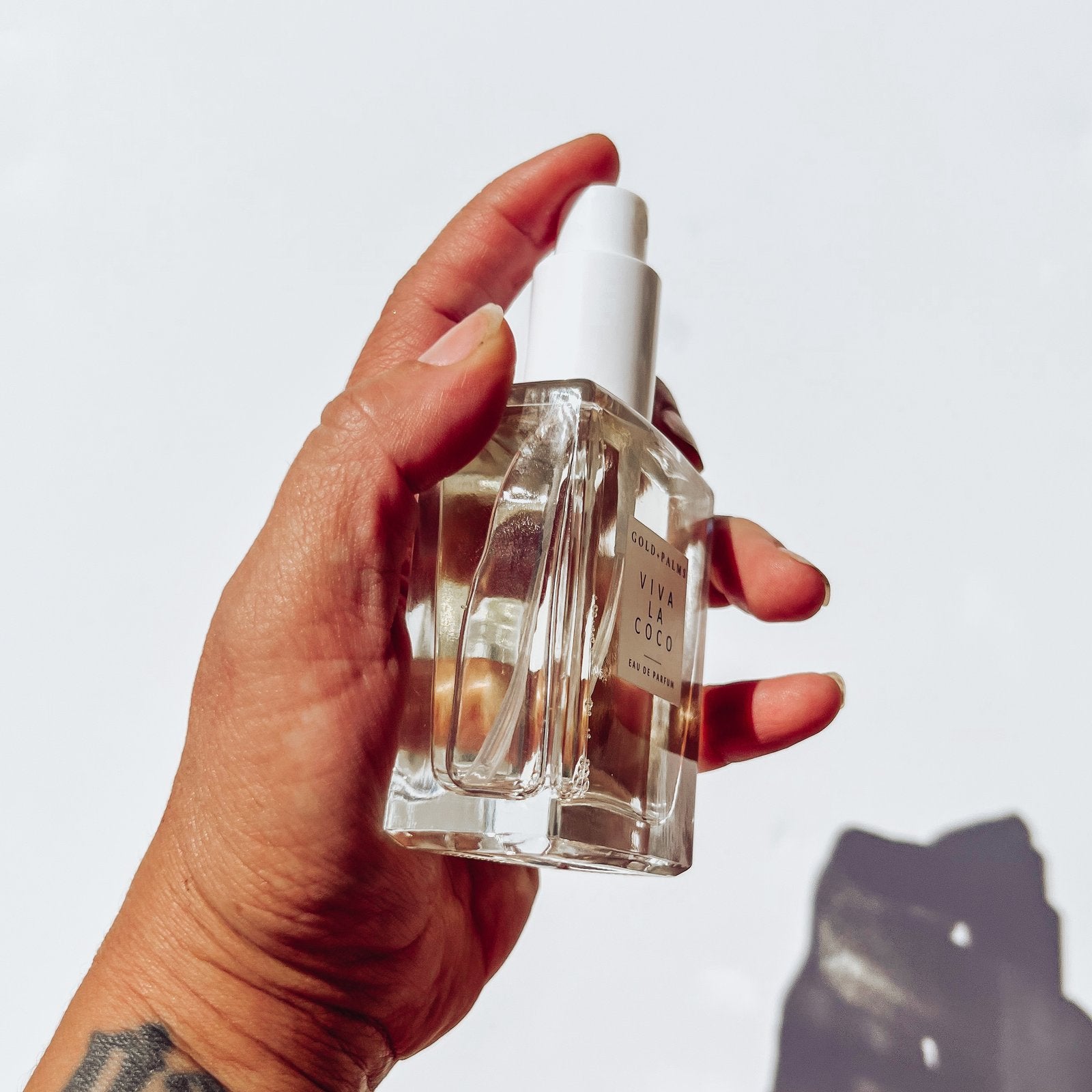 hand spraying 50 ml tobacco vanilla perfume with white background