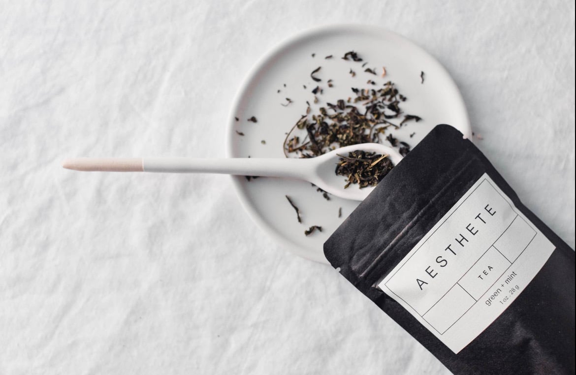 Aesthete tea blend with spoon and plate on white background 