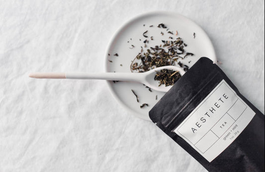 Aesthete tea blend with spoon and plate on white background 