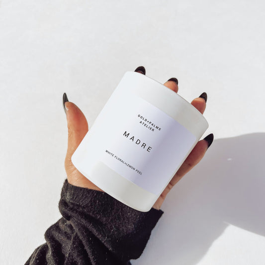 madre candle in palm against a white background