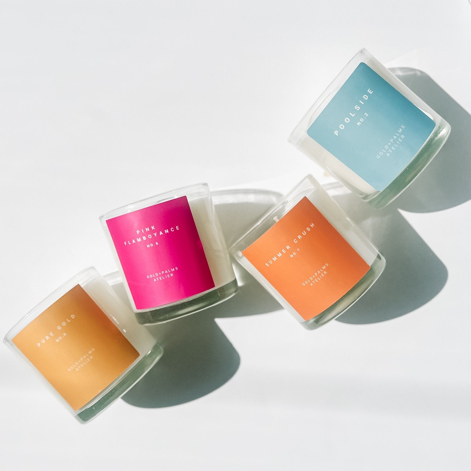 hotel inspired candle collection with colorful labels against white background