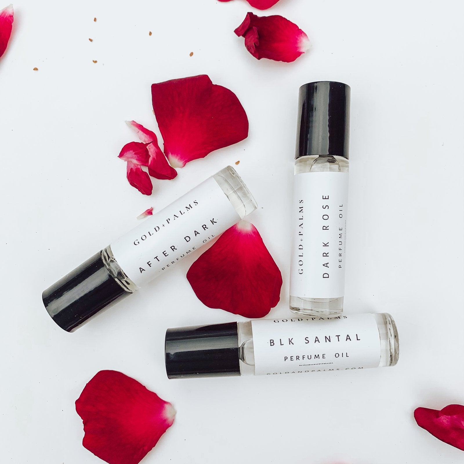 Sultry Vanilla perfume oil roll on with rose petals on white background